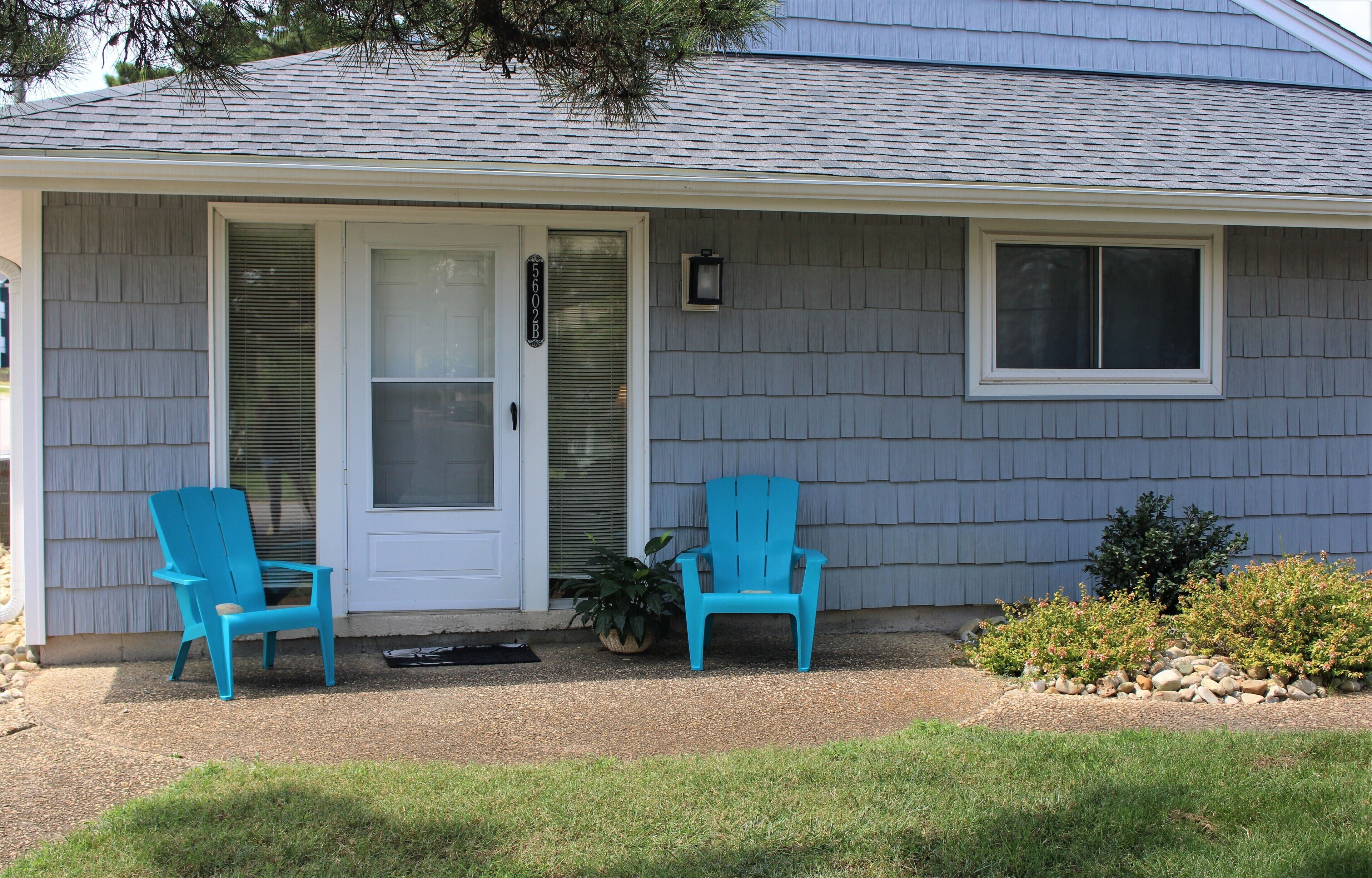 Ground-floor entrance at 5602B Atlantic Avenue with two blue Adirondack chairs