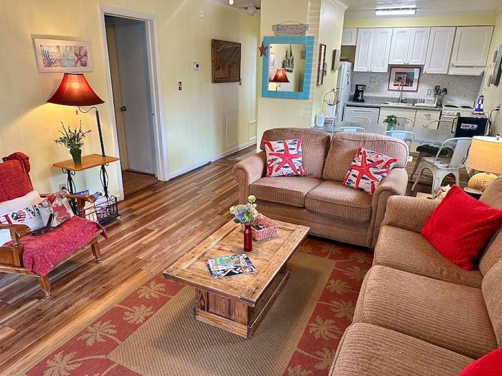 Beachcomber living area with sofa, armchair, and open kitchen beyond